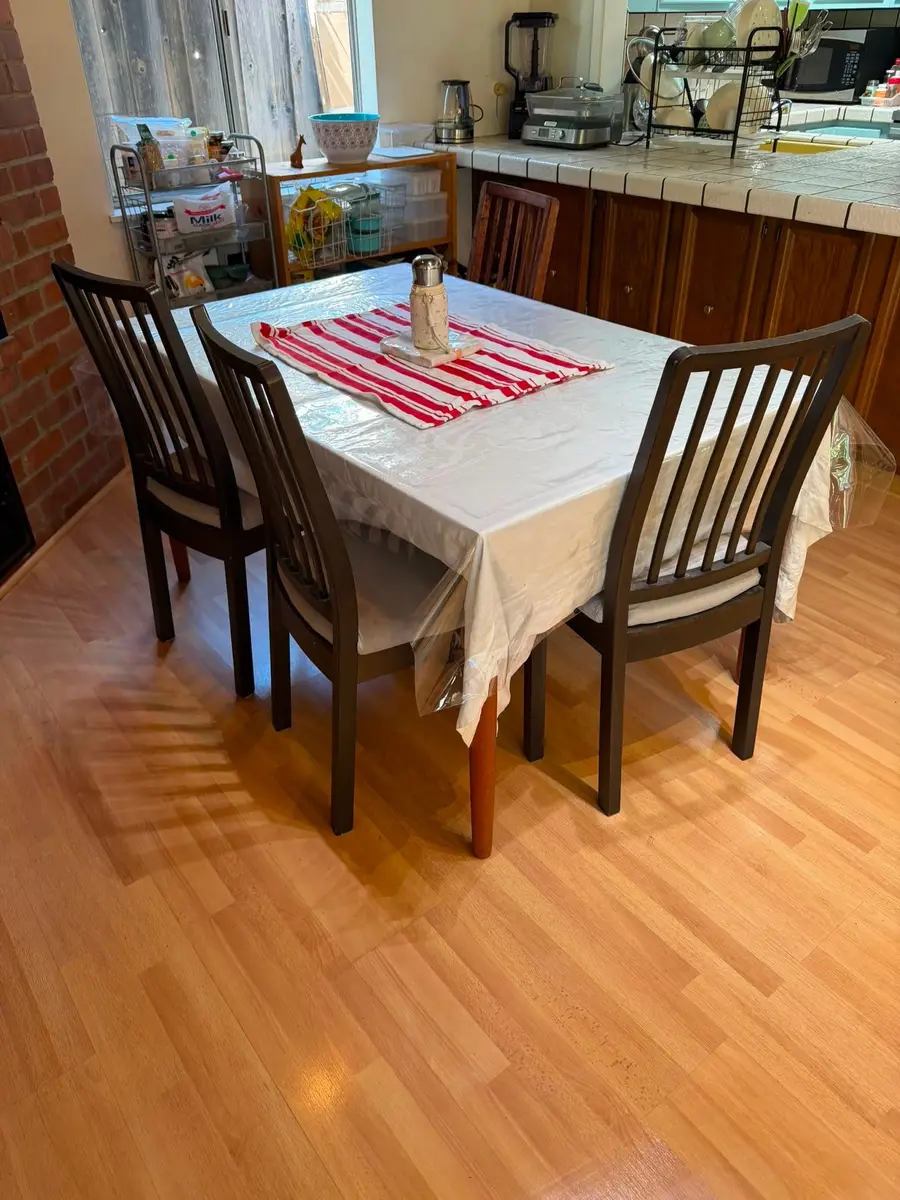 After: clear dining table with chairs tucked in and clean wood floor