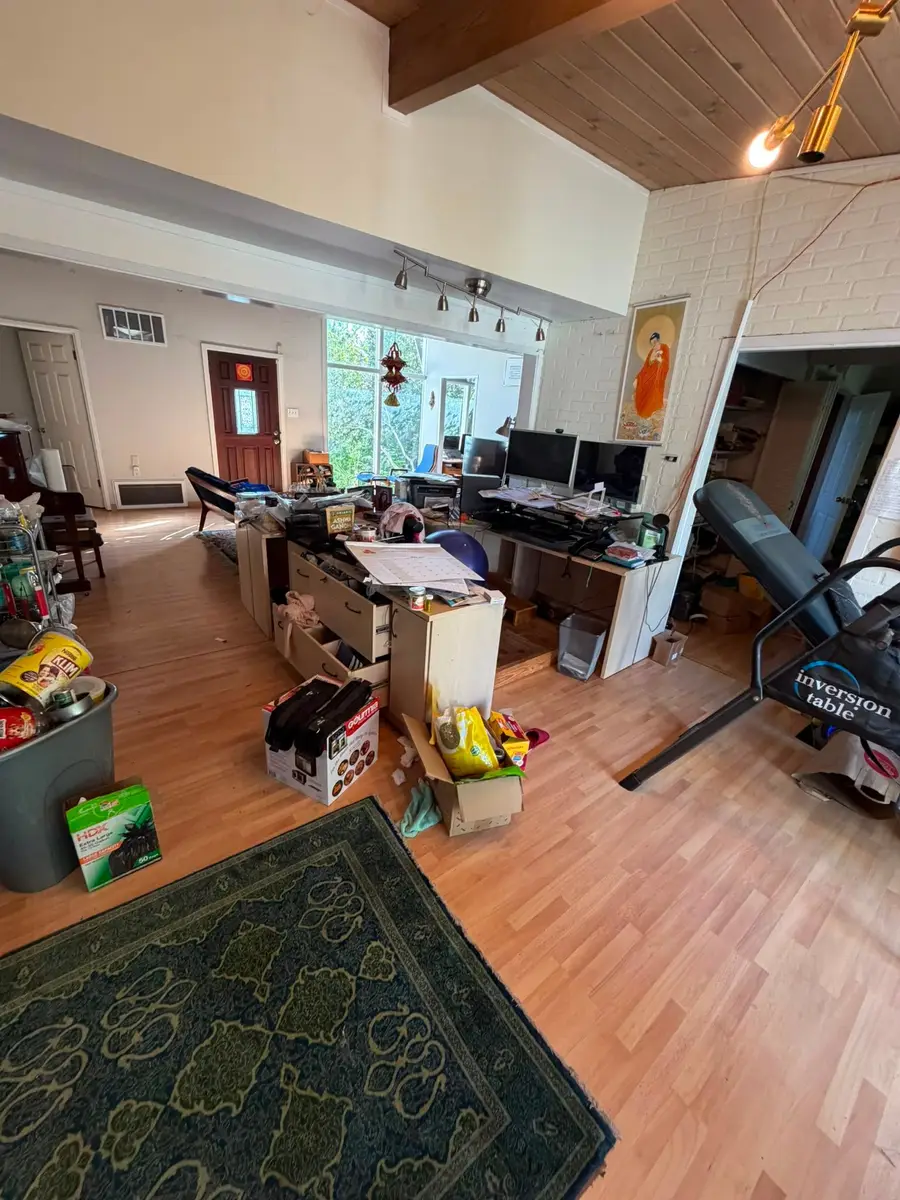 Before: living room and home office with boxes and clutter on the floor