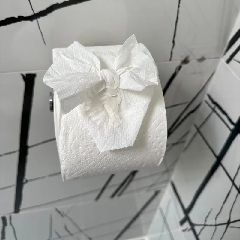Housekeeper making a bed with fresh white linens for an Airbnb turnover