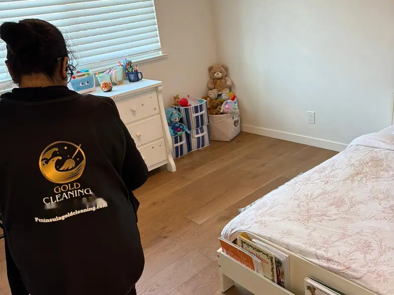 Peninsula Gold Cleaning team member in uniform tidying a child's bedroom